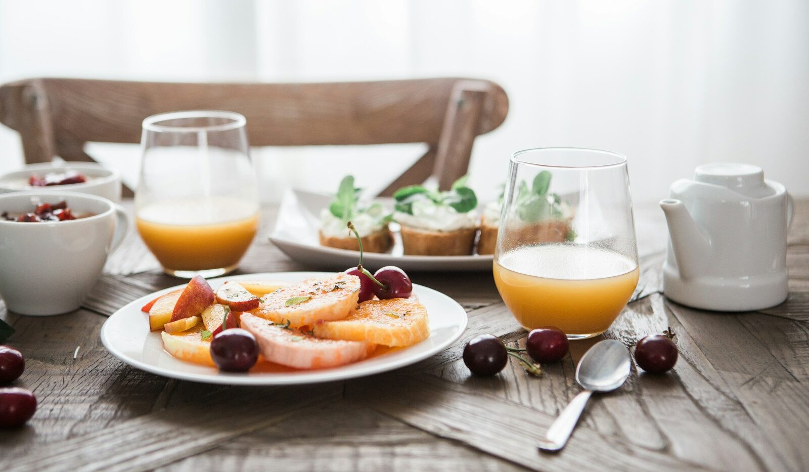 slice fruits on plate on near glass cups
